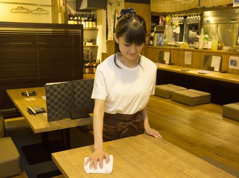 テーブルを拭くスタッフ